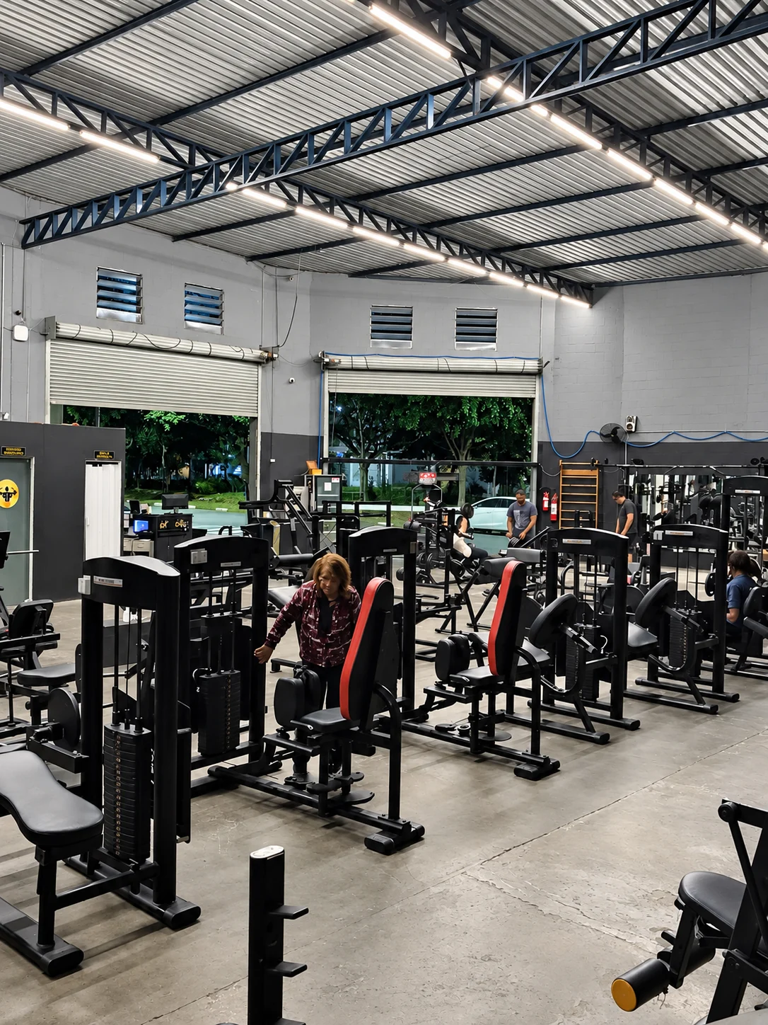 Área interna da academia com máquinas novas e grande pé-direito