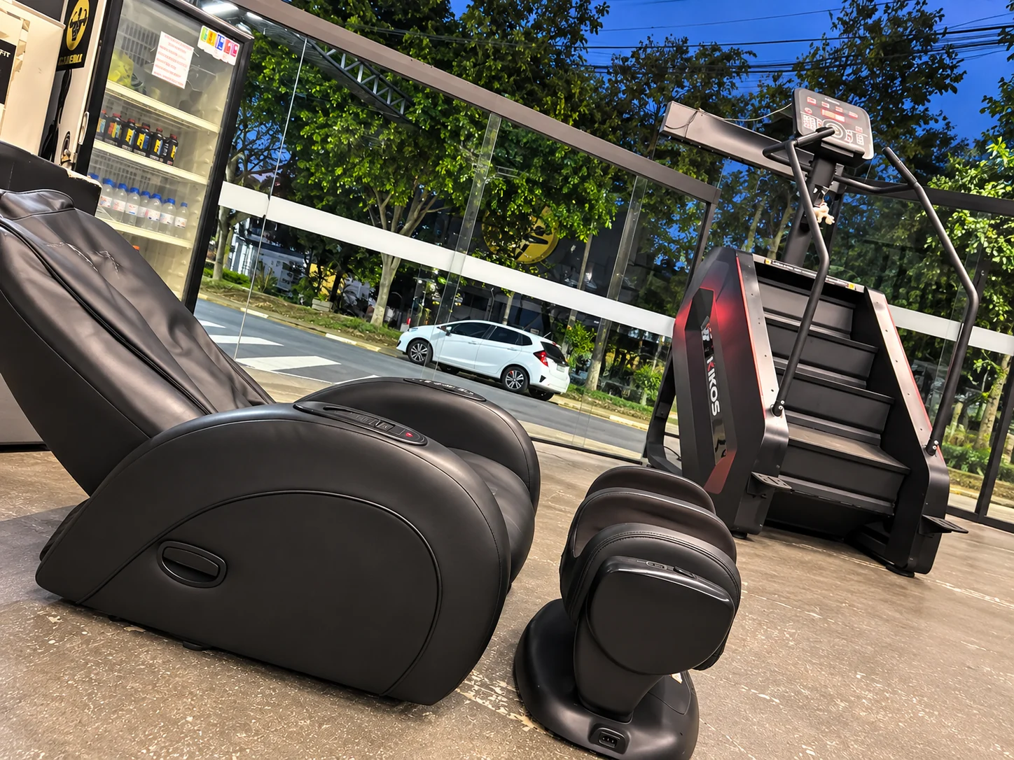 Poltrona de massagem e equipamento de cardio na academia